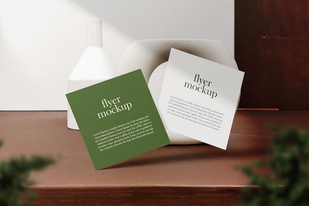 clean minimal square flyer mockup floating on wooden table with plant psd file