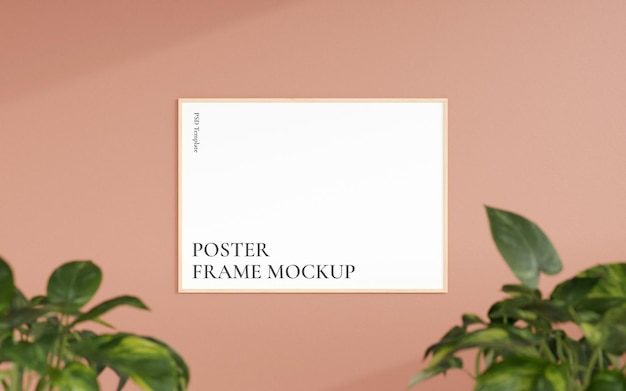 Clean and minimalist front view horizontal wooden photo or poster frame mockup hanging on the wall with blurry plant 3d rendering