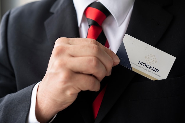 Close-up businessman putting business card mock-up in his pocket