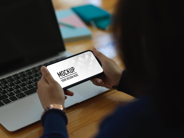 PSD close up of female hands using horizontal smartphone mockup