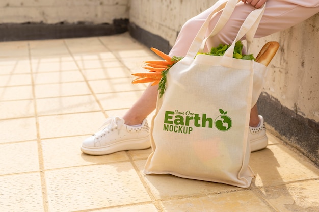 PSD close-up hand holding bag with carrots