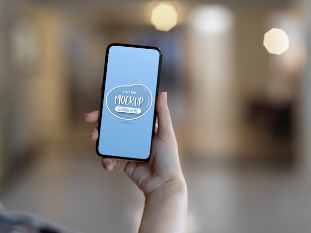 スマートフォンの画面のモックアップを持っている手にクローズアップ