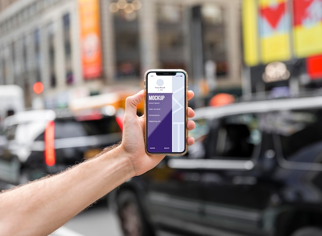 Close-up hand holding smartphone in city