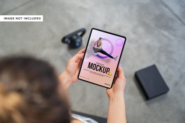 close up hand holding tablet mockup on gym background