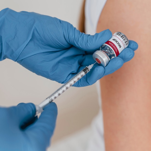 Close up hands holding vial and injection