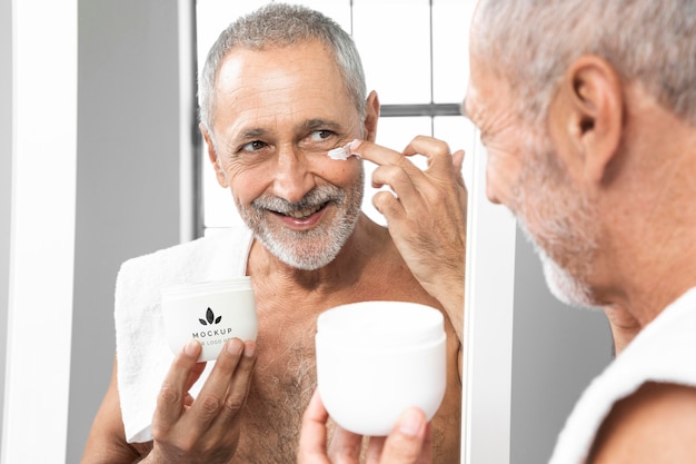 Close up man applying face cream