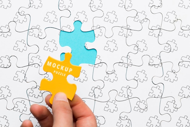 PSD close-up man holding a yellow piece of puzzle