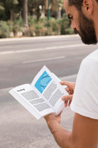 Close up man on street reading book