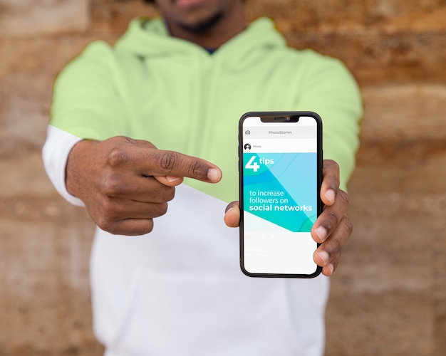 close-up man with hoodie showing mobile