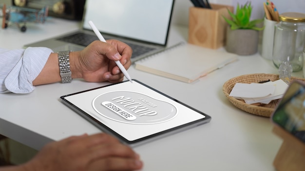 Close up view of businessman holding mockup digital tablet and stylus pen