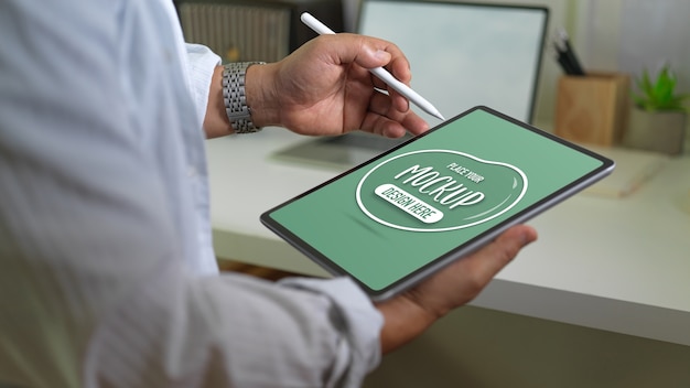 Close up view of businessman holding mockup digital tablet and stylus pen