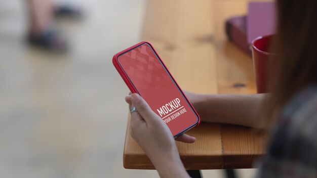 Close up view of female hands holding smartphone mockup