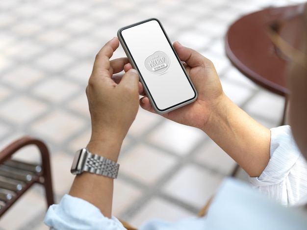 Close up view on hands holding smartphone with screen mockup