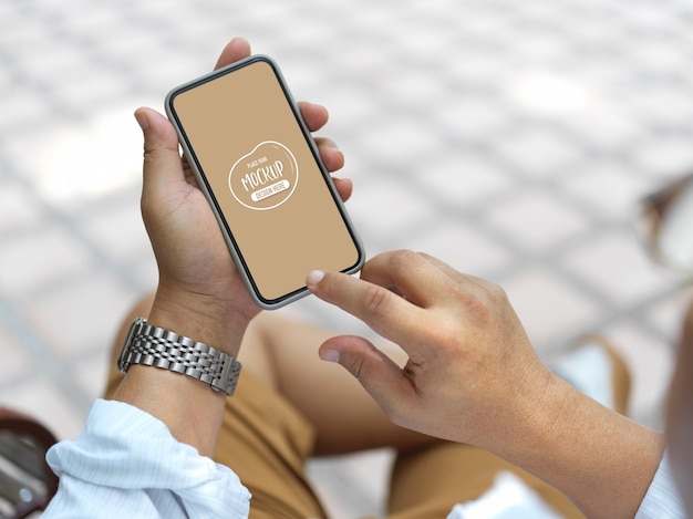 Close up view on hands holding smartphone with screen mockup