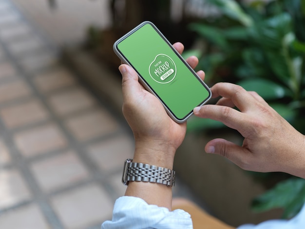 Close up view on hands holding smartphone with screen mockup