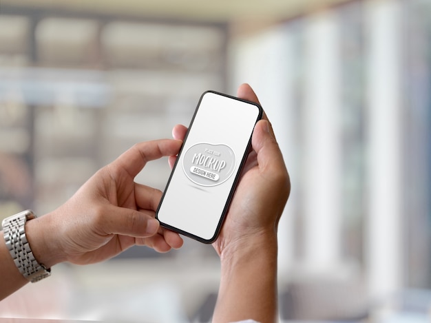 Close up view of male hands holding mock up smartphone