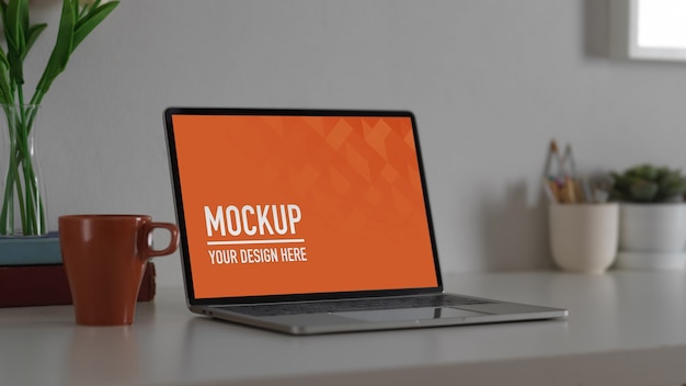 close up view of mockup laptop computer with office supplies in comfortable workspace