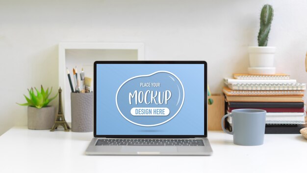 Close up view of office desk with mock up laptop, books, stationery and decorations