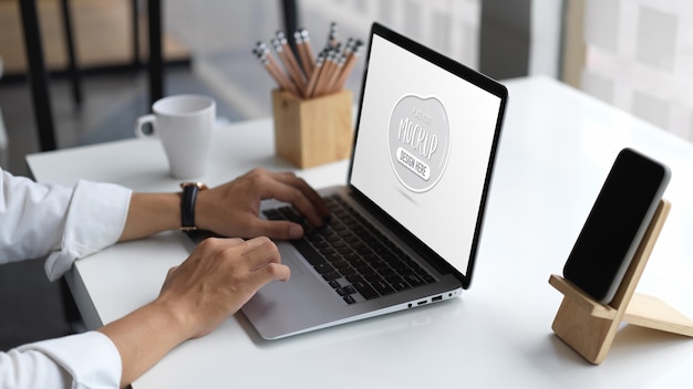 Close up view of young businessman typing on laptop mockup