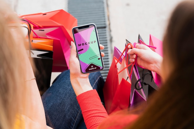 Smartphone della tenuta della donna del primo piano