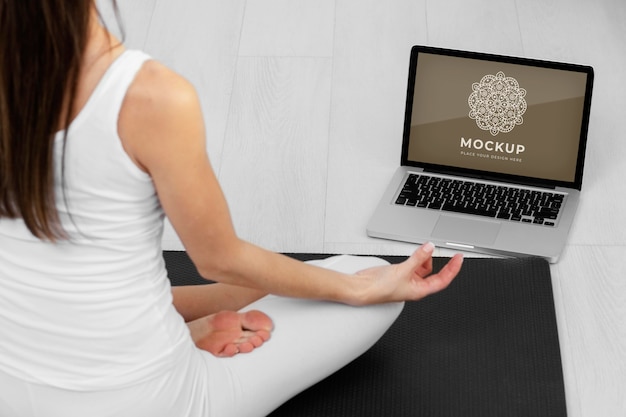 close up woman meditating with laptop