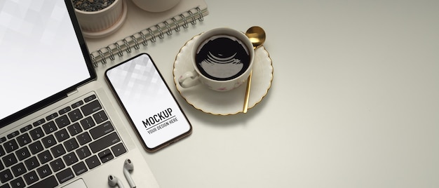close up of workspace with smartphone and laptop mockup
