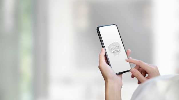 close up of young woman holding mockup smartphone