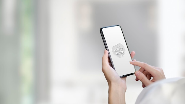 Close up of young woman holding mockup smartphone