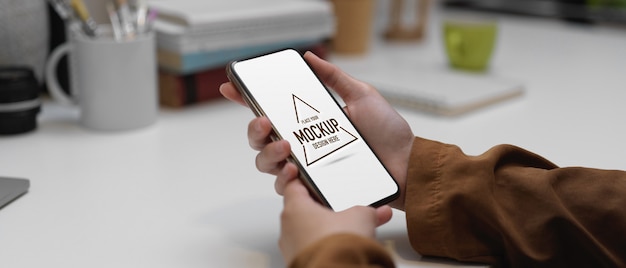 モックアップスマートフォンを保持している手のクローズアップビュー