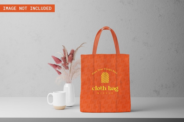 PSD cloth bag mockup with flower decoration and mug