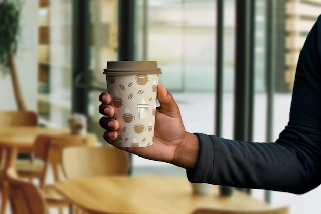 Coffee cup mockup with latte art and patterned design on a plain background
