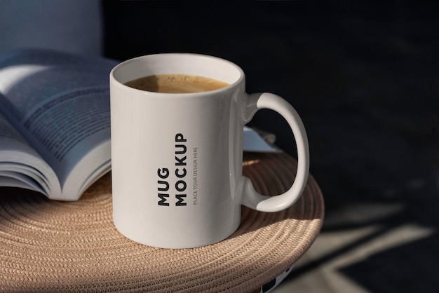 A coffee mug mockup on a table with a book