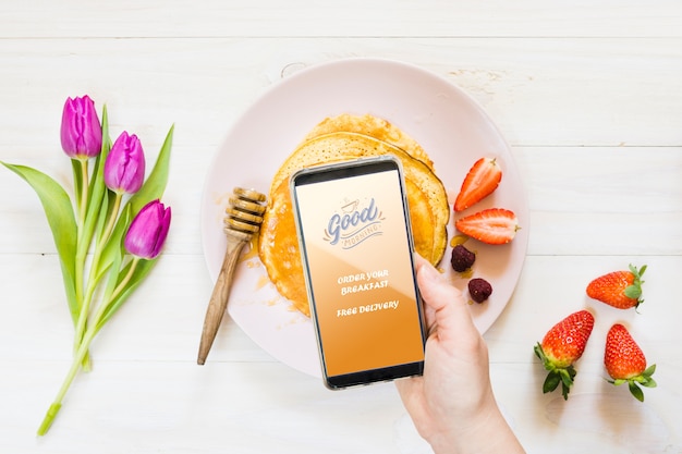 Collection of breakfast pancakes next to smartphone