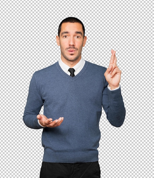 Concerned young man doing a crossed fingers gesture