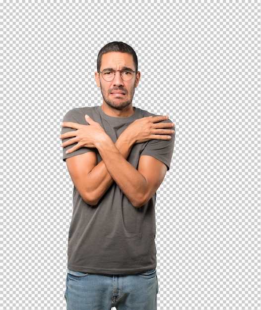 concerned young man making a gesture of being cold