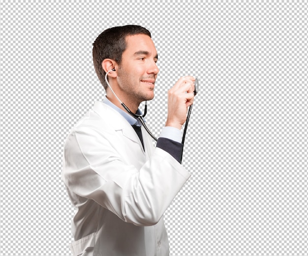 Confident doctor using a stethoscope against white background