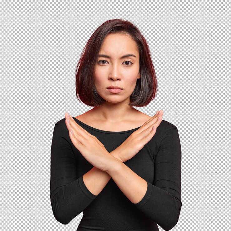 PSD confident serious asian woman crosses hands makes stop forbid sign rejects something and says no wears black jumper isolated over vivid red background says no has determined face expression