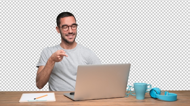 自分の机に座って手を指している自信を持った若い男