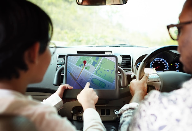 PSD couple in a car finding direction on a tablet with gps