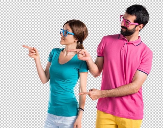 Couple in colorful clothes pointing to the lateral