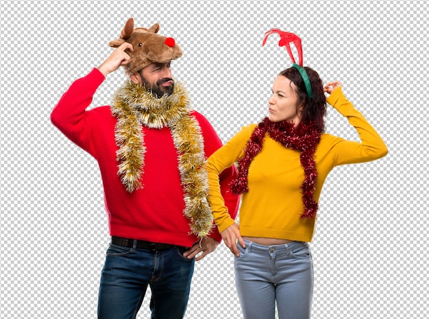 PSD couple dressed up for the christmas holidays having doubts and with confuse face