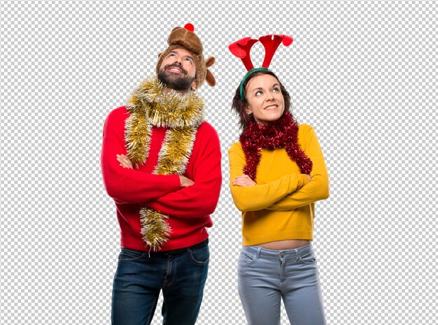 PSD couple dressed up for the christmas holidays looking up while smiling