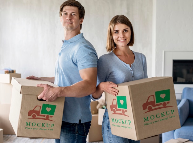 Couple holding boxes for their new home and being happy