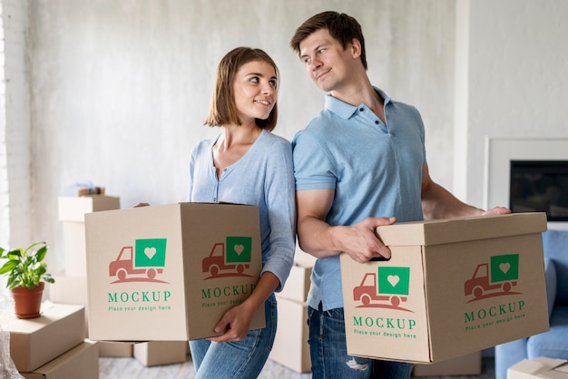 Couple holding boxes for their new home and looking at each other