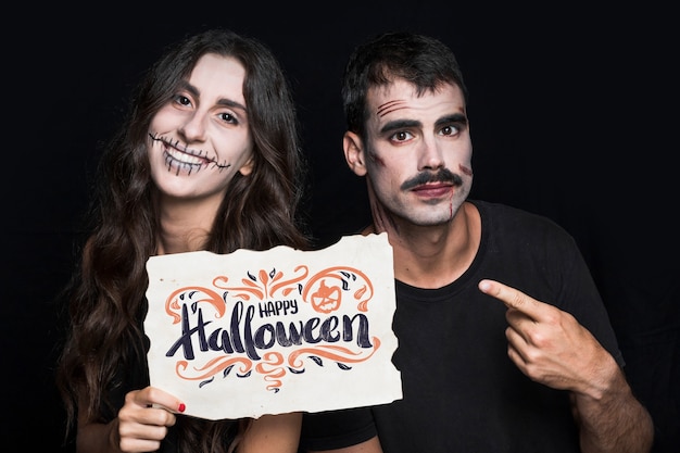 Couple holding paper with halloween lettering