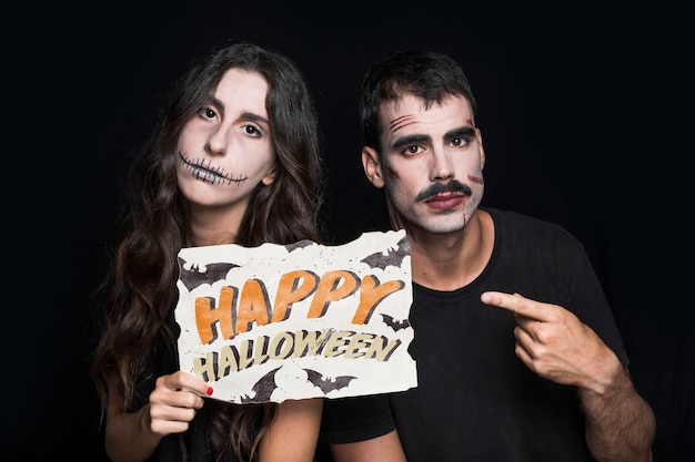 Couple holding paper with halloween lettering