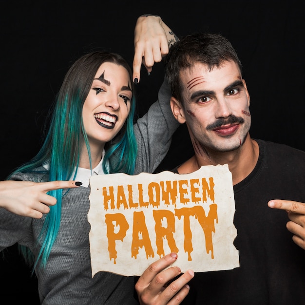 Couple holding paper with halloween lettering