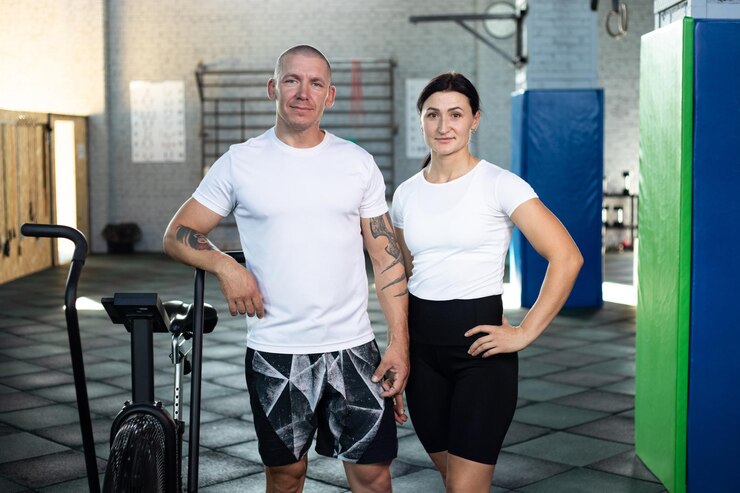 PSD couple posing in gym next to aerobic bike