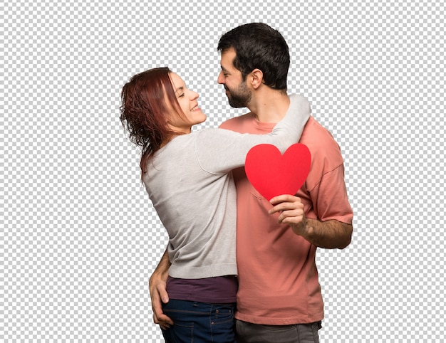 Couple in valentine day holding a heart symbol and kissing