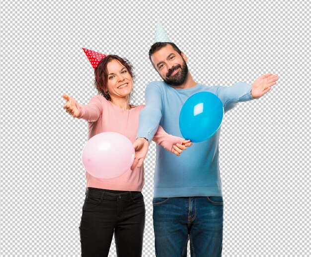 PSD couple with balloons and birthday hats presenting and inviting to come. happy that you came